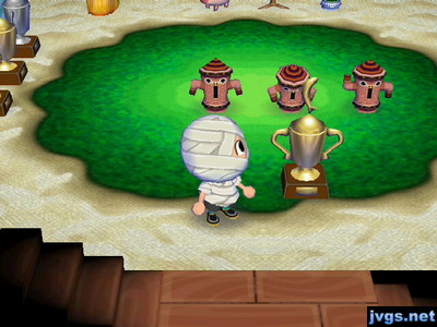 Jeff the mummy standing next to a gold trophy.