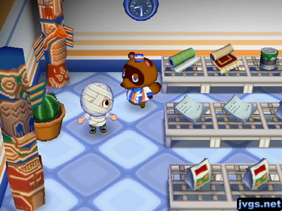 Two totem poles on sale in Nook 'n' Go, with a cactus in between them.