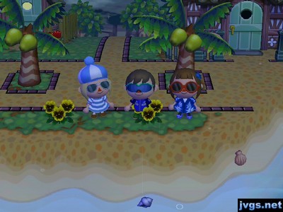 Megan, Jeff, and Yann wearing sunglasses on the beach.