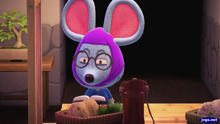 A close-up picture of Rizzo the mouse reading, with glasses on.