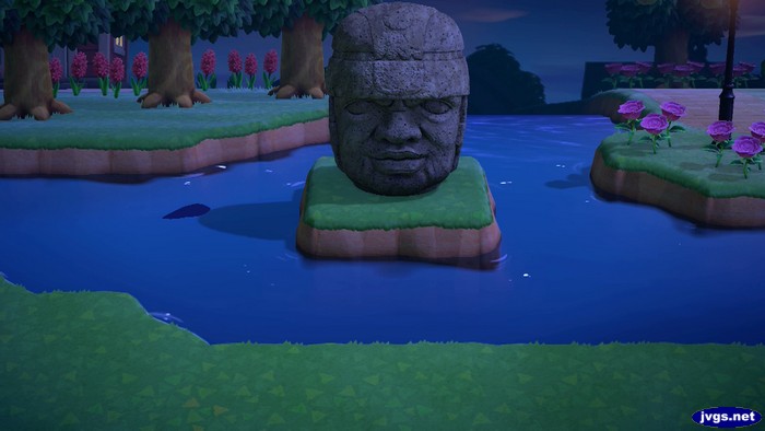 A rock-head statue on an island in the river in Animal Crossing: New Horizons (ACNH).