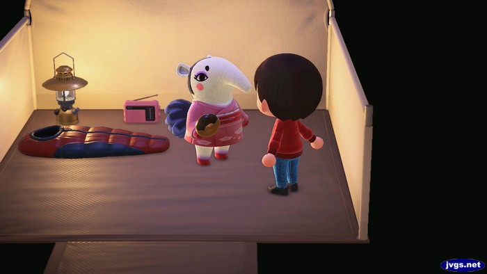 Annalisa camping at the campsite and holding a donut.