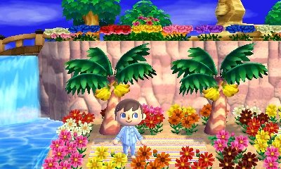 The view from the beach, with flowers, a waterfall, and a glimpse of the Sphinx in Lion Village.