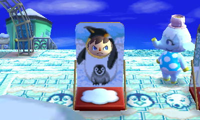A face-cutout standee featuring a penguin and its baby, in the New Leaf dream town of Sutton.