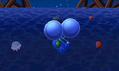 A silver slingshot on balloons floats by as I swim in the ocean.