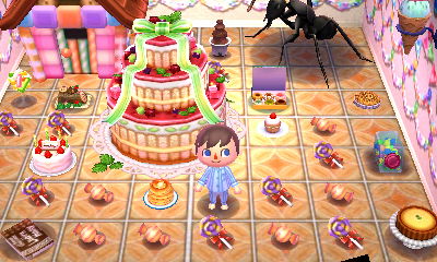 A room full of sweets, including a giant cake and a gingerbread house. A giant ant is also nearby.