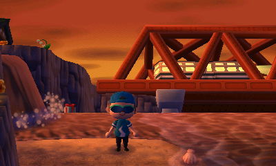 A train rides over the bridge at sunset in Animal Crossing: New Leaf.